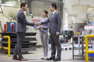 Business people shaking hands in factory